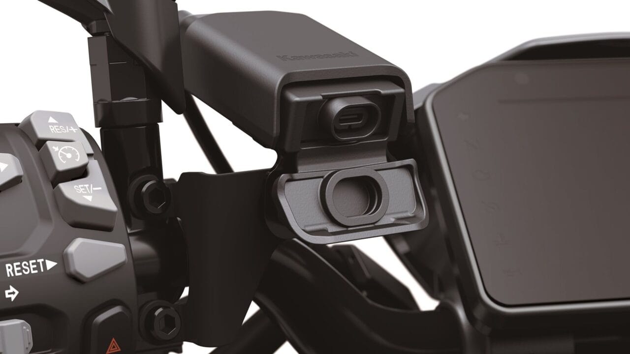 Close-up of a Kawasaki motorcycle handlebar with reset button and control switches on the left side.