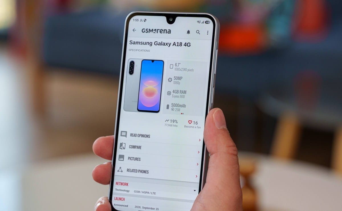 Hand holds a smartphone displaying the GSM Arena page for Samsung Galaxy A18 4G with specs and images on the screen