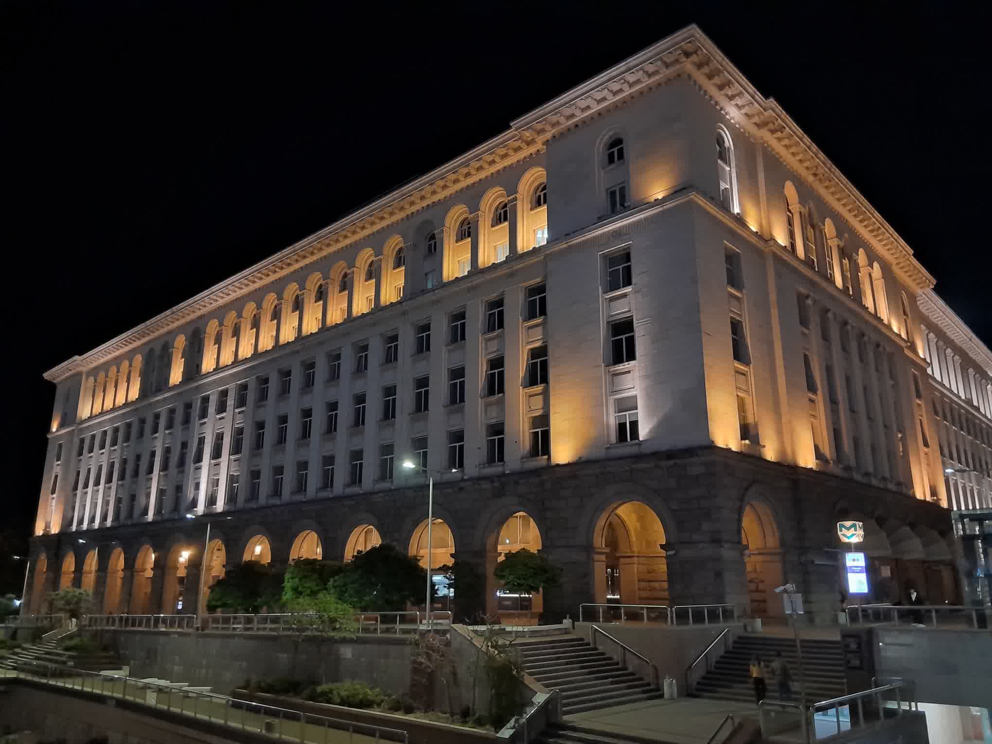 Night view of a grand historic building at night, illuminated arches along the ground floor and warm lights highlighting the facade.