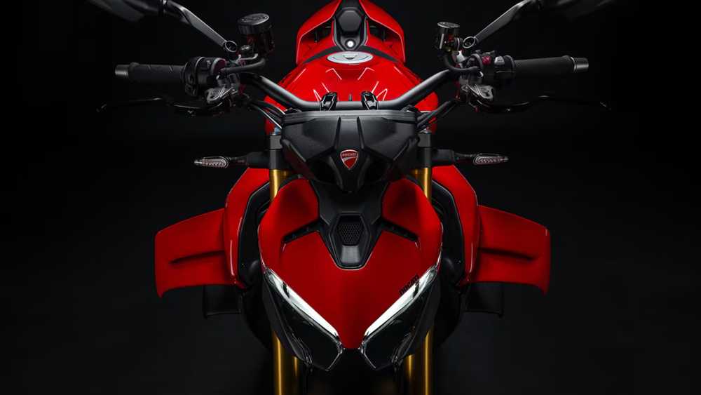 Front-on view of a red sport motorcycle with aggressive angular bodywork and gold front forks against a dark background