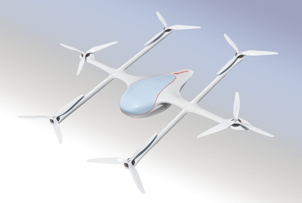 White quadcopter drone with a rounded blue cockpit in flight against a pale gradient sky, four rotor arms visible