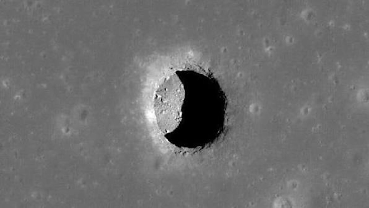 Moon surface crater with a deep, circular shadowed interior and bright rim edges.