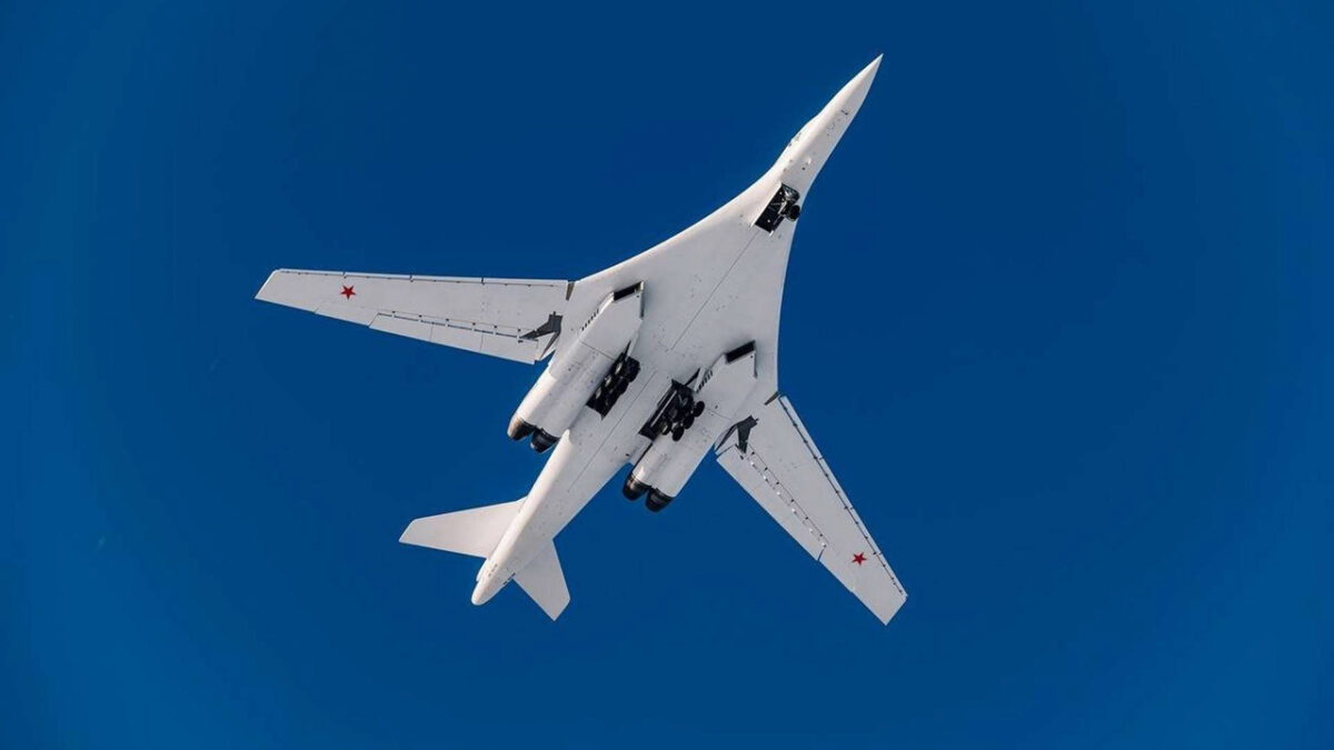 نمای زیرین بمب‌افکن راهبردی مافوق صوت توپولف Tu-160 روسیه با بال‌های متغیر در حال پرواز در آسمان آبی