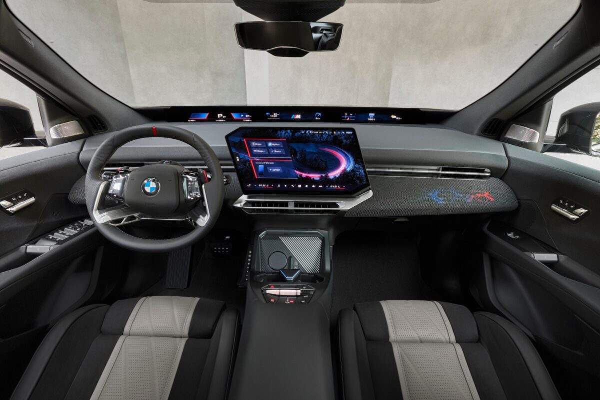نمای کامل داشبورد BMW iX3 M60 xDrive با فرمان اسپرت M، نمایشگر مرکزی ۱۷.۹ اینچی، سیستم Panoramic iDrive و نورپردازی اختصاصی کابین