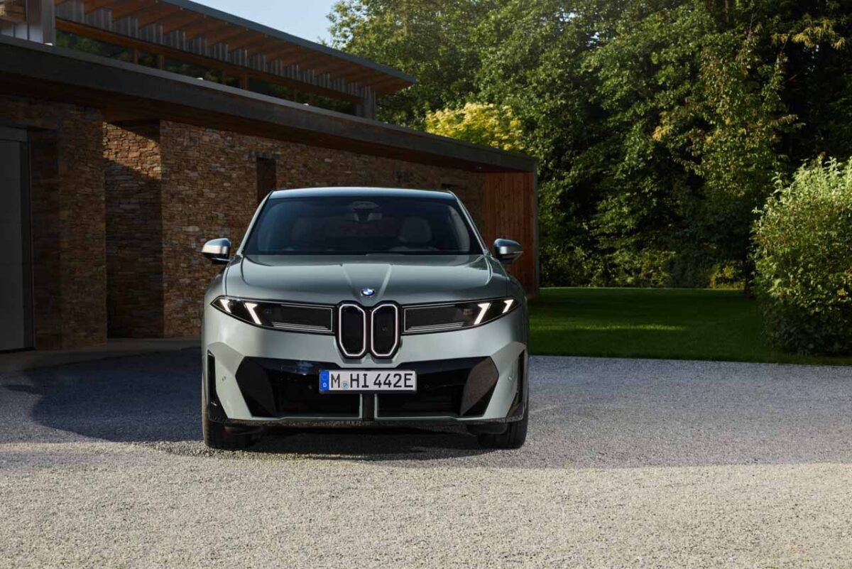نمای روبه‌روی شاسی‌بلند برقی BMW iX4 نقره‌ای با جلوپنجره کلیوی عمودی، چراغ‌های LED روشن و طراحی مدرن سپر جلو