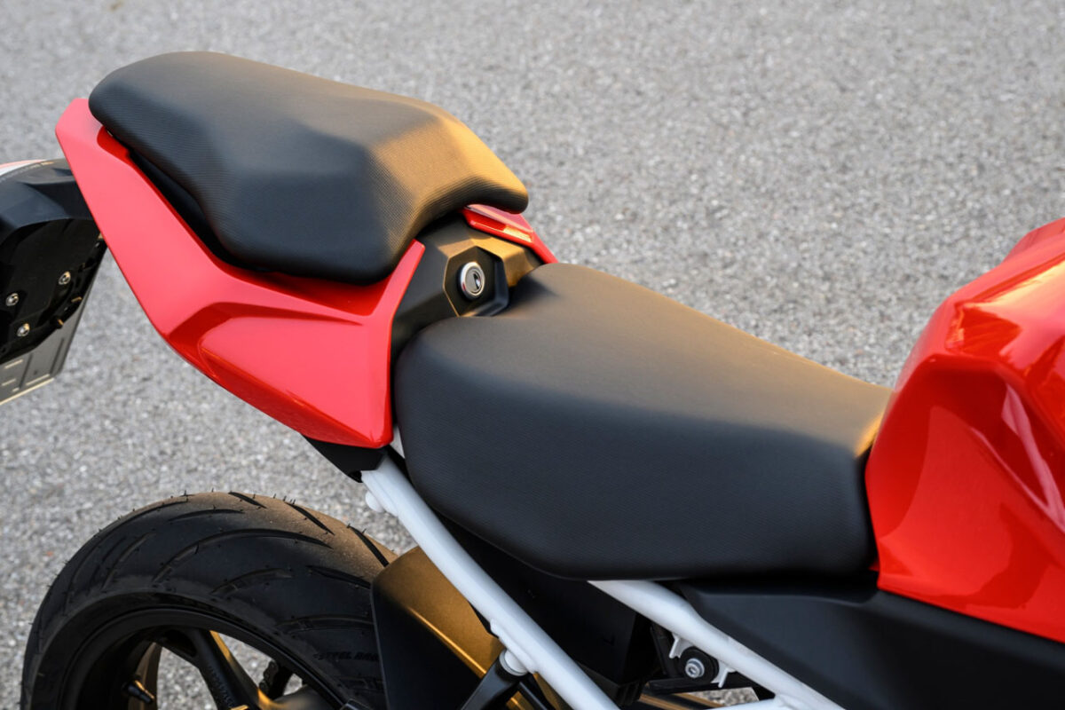 نمای نزدیک زین دو‌بخشی مشکی موتورسیکلت BMW F 450 RR با طراحی اسپرت و بدنه قرمز در قسمت عقب