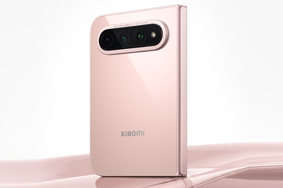 پشت گوشی تاشو Xiaomi 18 Fold نسخه سرامیکی با بدنه صورتی روشن براق و ماژول دوربین افقی سه‌گانه با حلقه طلایی که روی سطح صدفی صورتی در نور استودیویی ایستاده است.