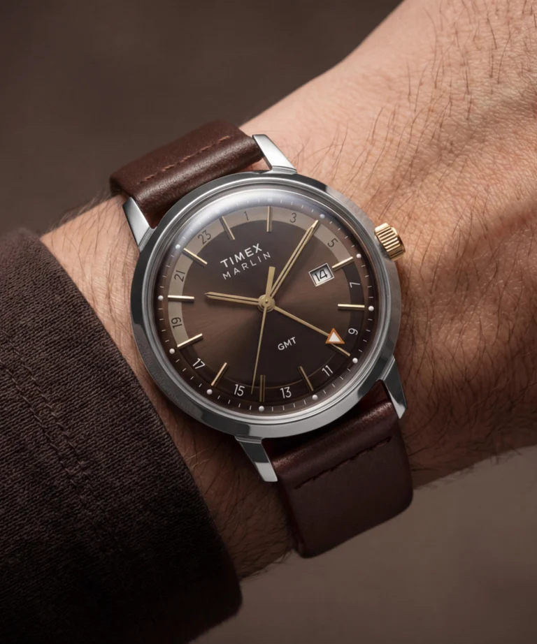 نمای ساعت مچی Timex Marlin GMT روی دست با صفحه قهوه‌ای سان‌برست، عقربه‌های طلایی و بند چرمی قهوه‌ای تیره