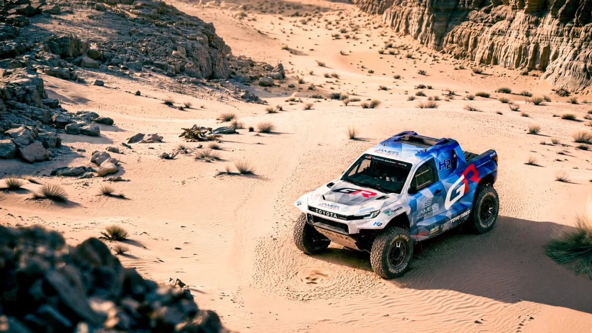 نمای بالاتر از وانت پیکاپ هیدروژنی Toyota DKR GR FC Hilux در مسیر شنی و صخره‌ای بیابان
