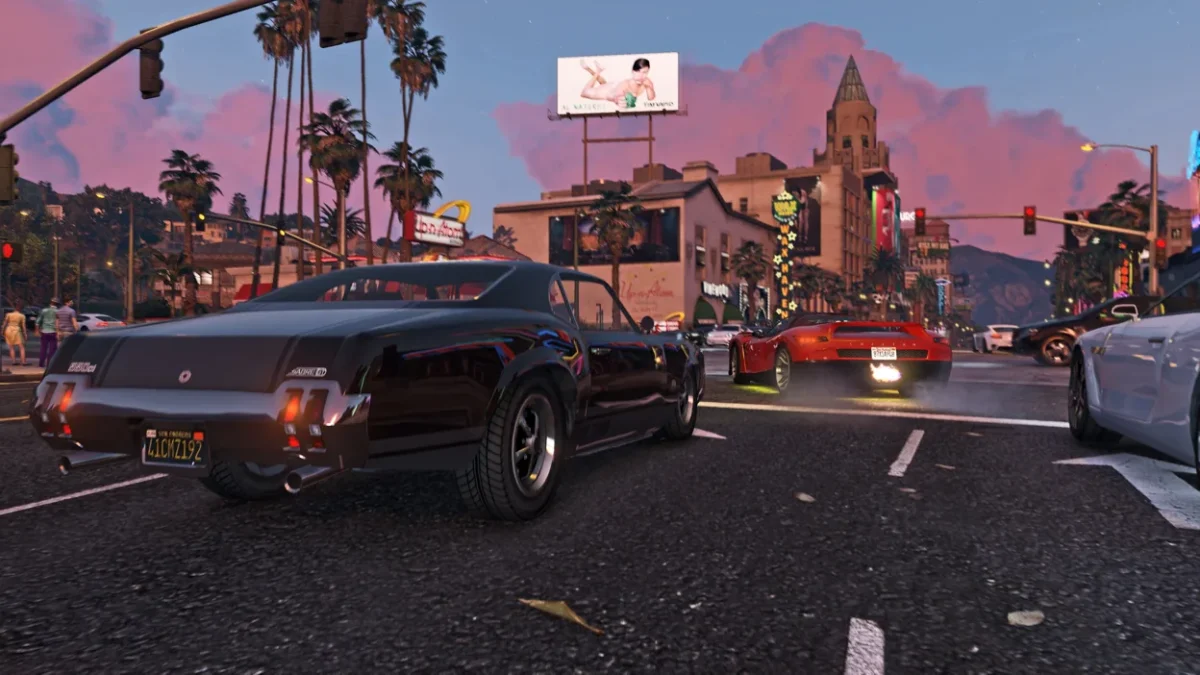 نمایی از گیم‌پلی Grand Theft Auto VI در خیابانی شلوغ هنگام غروب؛ چند خودروی اسپرت میان ساختمان‌های شهری و نخل‌ها حرکت می‌کنند و آسمان با ابرهای صورتی‌رنگ پوشیده شده است.