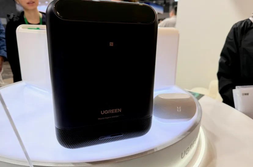 پنل جلویی ذخیره‌ساز هوشمند مشکی رنگ برند UGREEN مجهز به علامت NFC و بلندگوی هوشمند کوچک در کنار آن روی استند نمایشگاه.