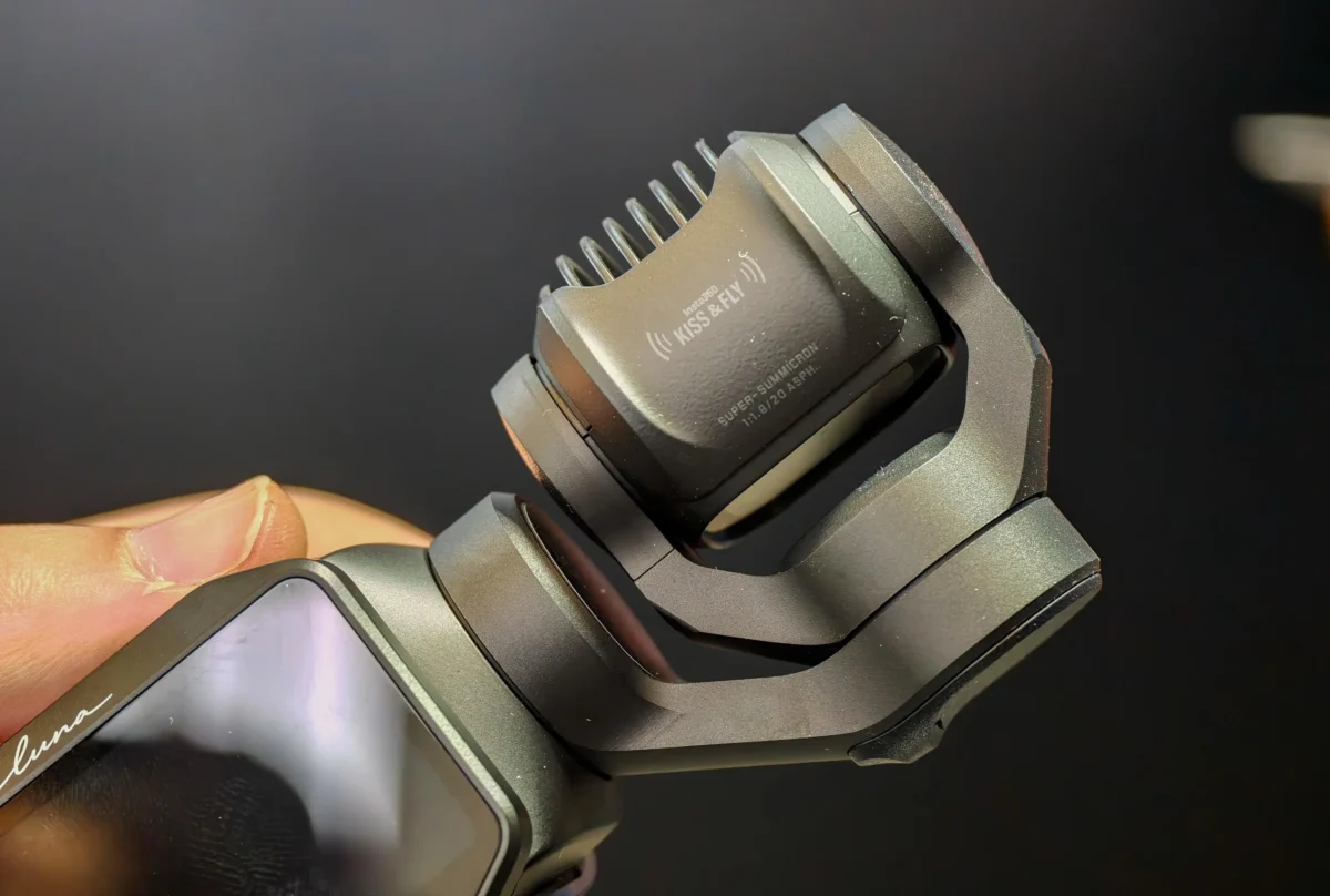 نمای نزدیک از ماژول گیمبال و هد لنز دوربین Insta360 Luna مجهز به لنز Leica Super-Summicron و شیارهای خنک‌کننده در بدنه خاکستری تیره.