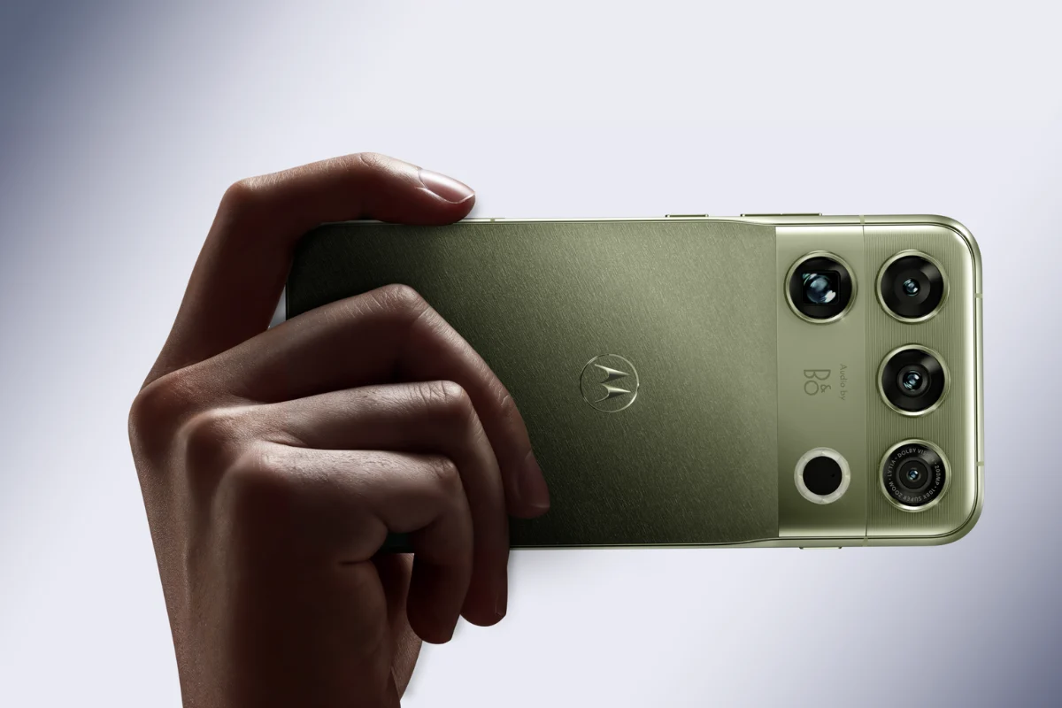 نمای پشت گوشی سبز زیتونی Motorola Signature که در دست نگه داشته شده و ماژول دوربین چندگانه آن با لنزهای گرد در گوشه بدنه دیده می‌شود.