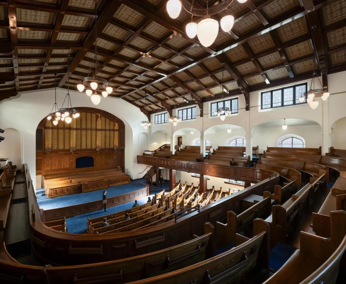 فضای داخلی مرمت‌شده کلیسای First Baptist Church با نیمکت‌ها و سقف چوبی