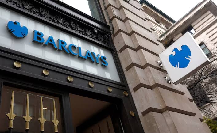 نمای ورودی و تابلوی سردر شعبه بانک بارکلیز (Barclays) با نشان عقاب آبی و حروف برجسته بر روی ساختمان سنگی کلاسیک.