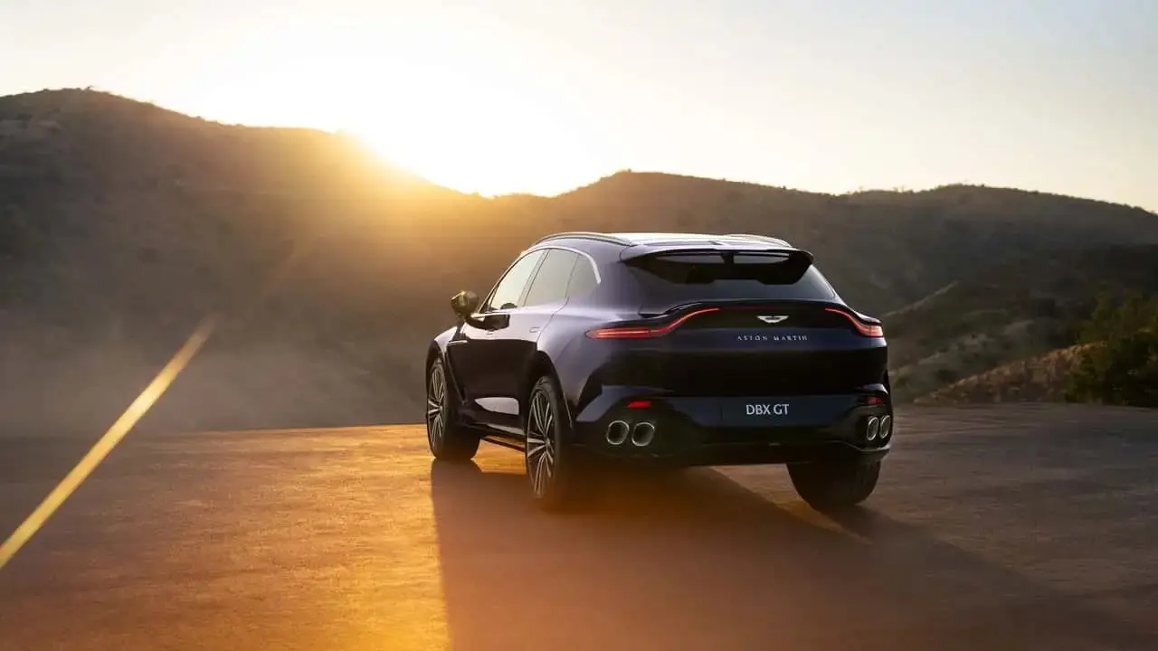 شاسی‌بلند استون مارتین (Aston Martin) DBX GT در مسیر کوهستانی هنگام غروب