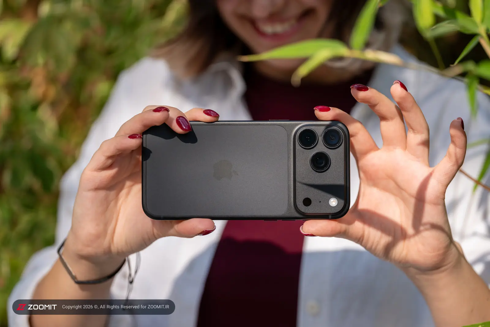 گوشی آیفون ۱۸ پرو مکس (iPhone 18 Pro Max) با بدنه مشکی در دست یک زن