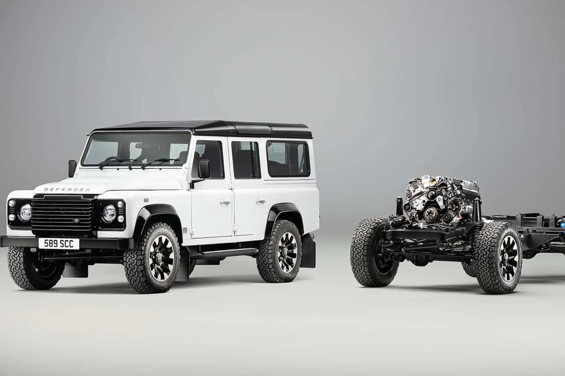 لندرور دیفندر کلاسیک سفید در کنار موتور V8 جدید