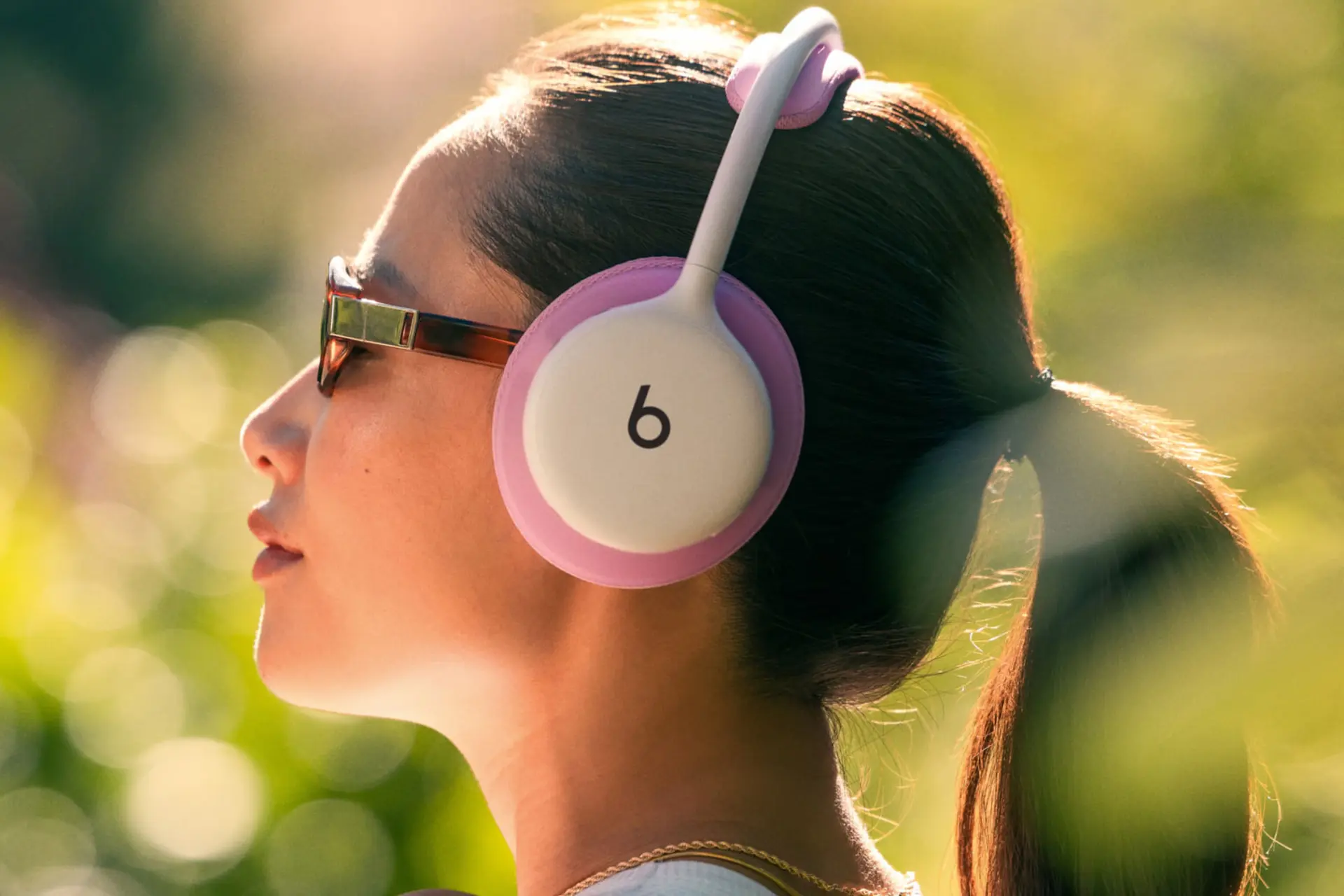 هدفون بیتس ۳۶۰ (Beats 360) با بالشتک‌های صورتی روی سر یک زن