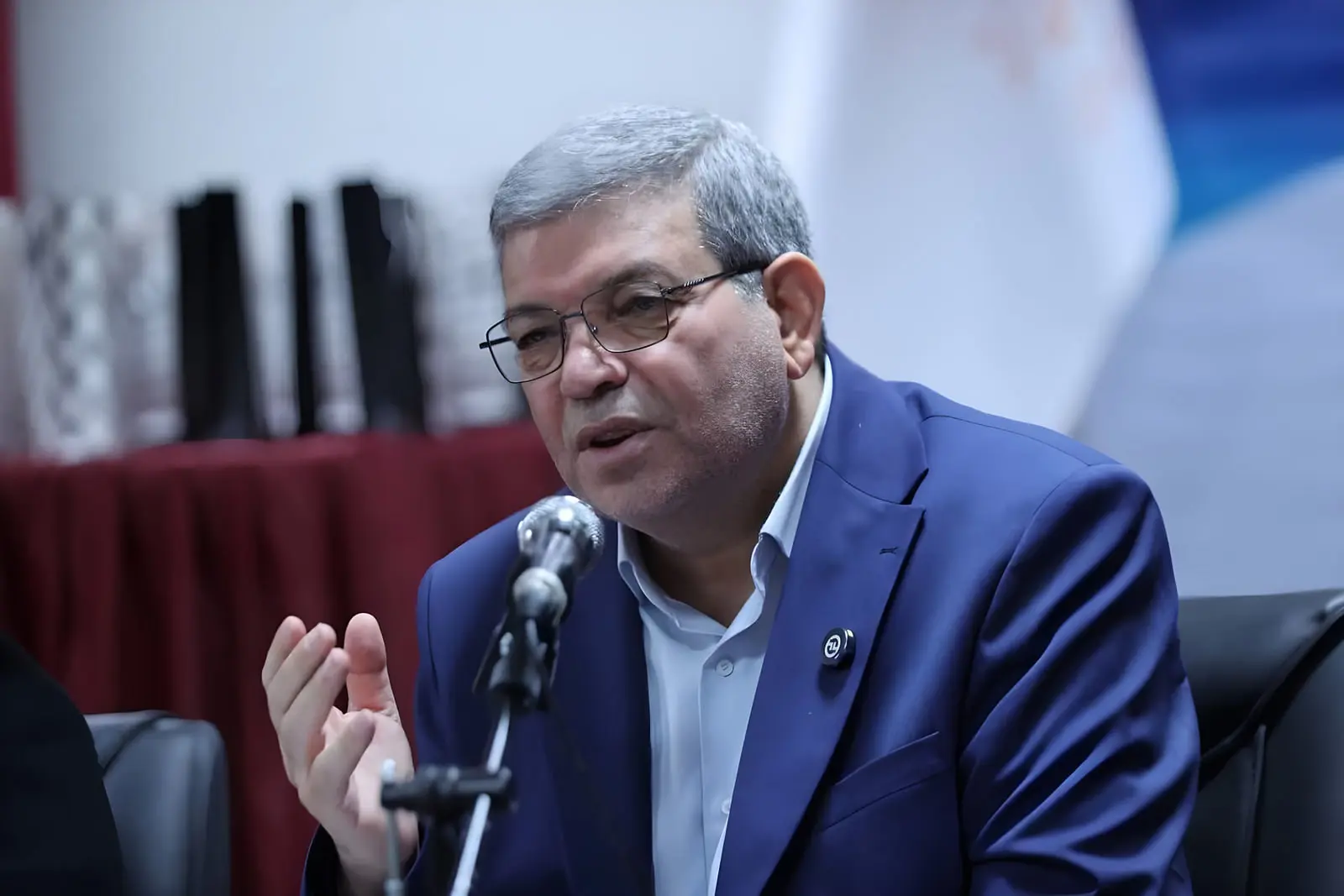 رئیس سازمان بهزیستی در حال صحبت در نشست خبری مربوط به اینترنت نیم‌بها