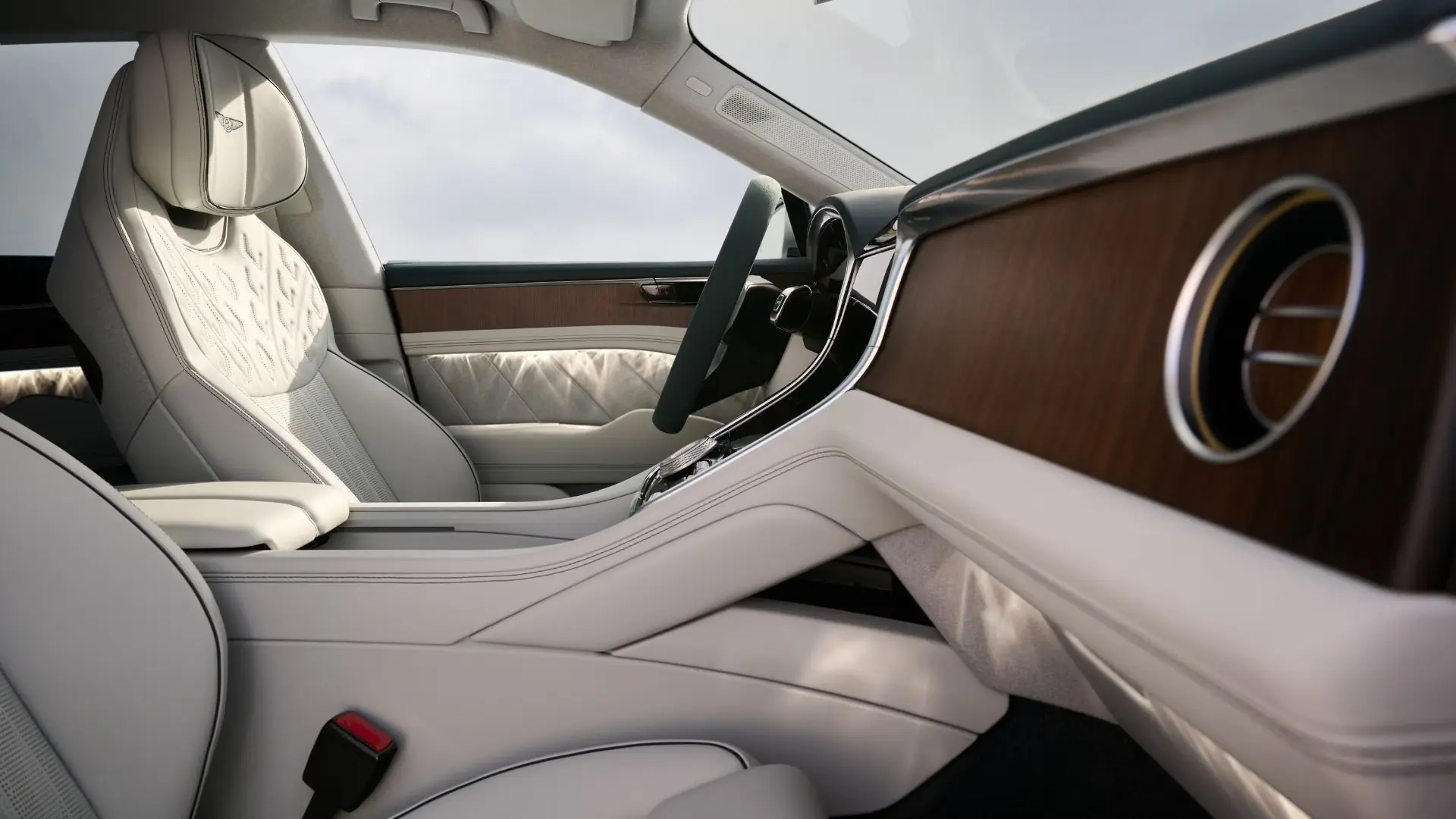 کابین لوکس خودروی بنتلی (Bentley) با صندلی‌های چرمی سفید و پنل چوبی