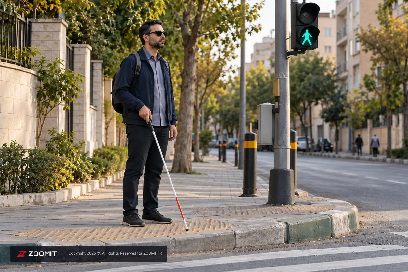 مرد نابینا با عصای سفید در حال ایستادن کنار چراغ راهنمایی سبز