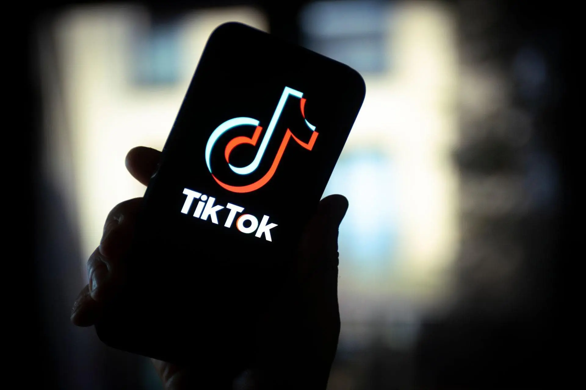 لوگو تیک تاک / TikTok رنگی در دست روی نمایشگر