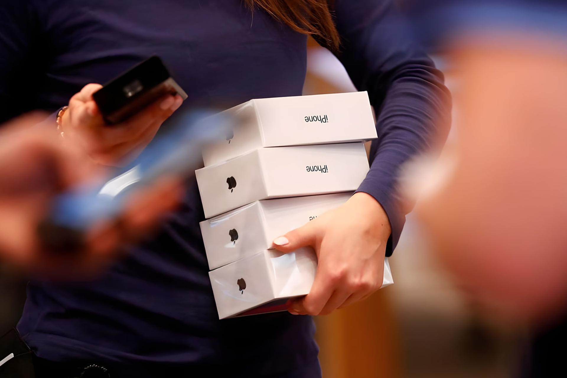 جعبه‌های گوشی آیفون (iPhone) در دست یک مشتری