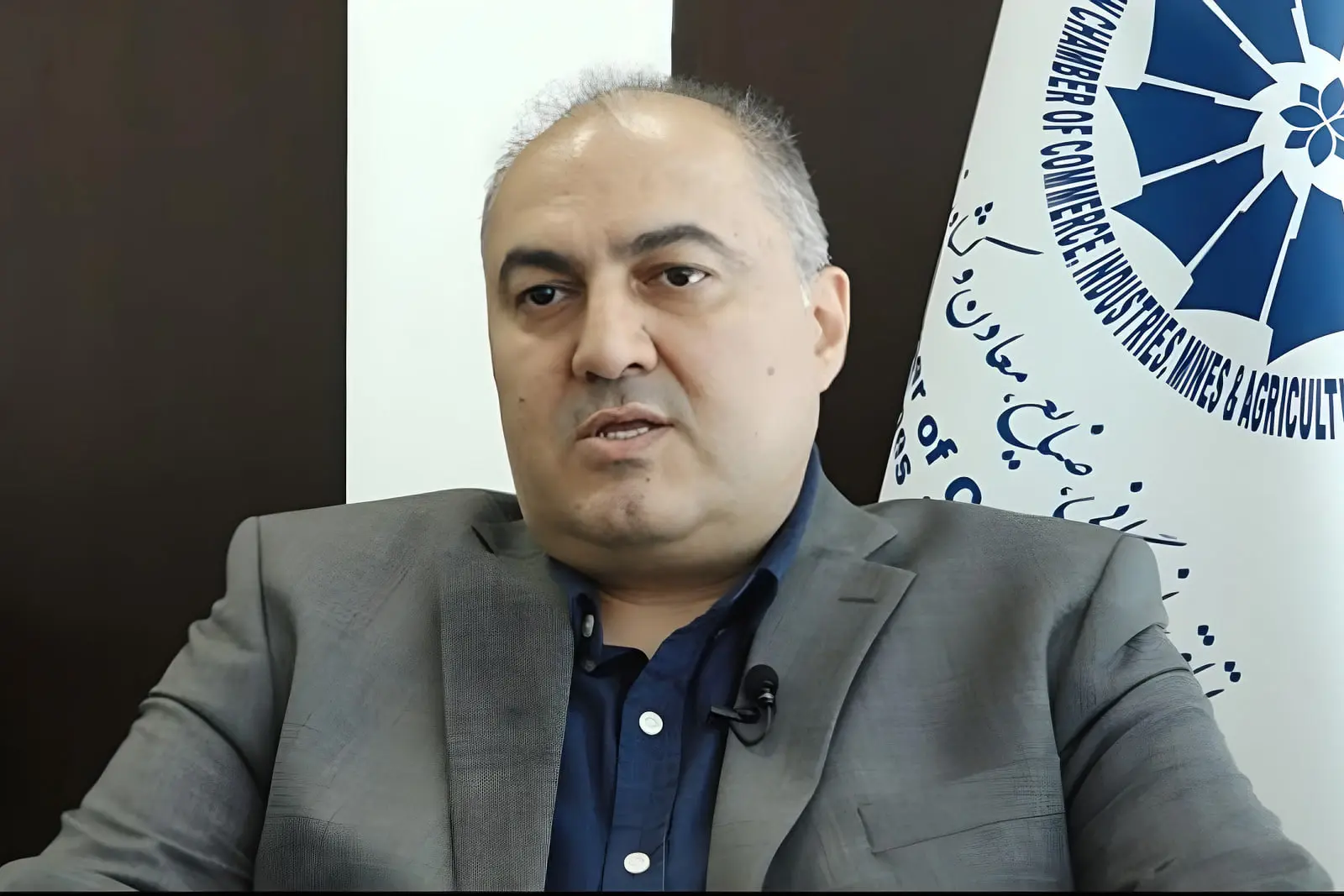 افشین کلاهی در مقابل پرچم اتاق بازرگانی صنایع معادن و کشاورزی