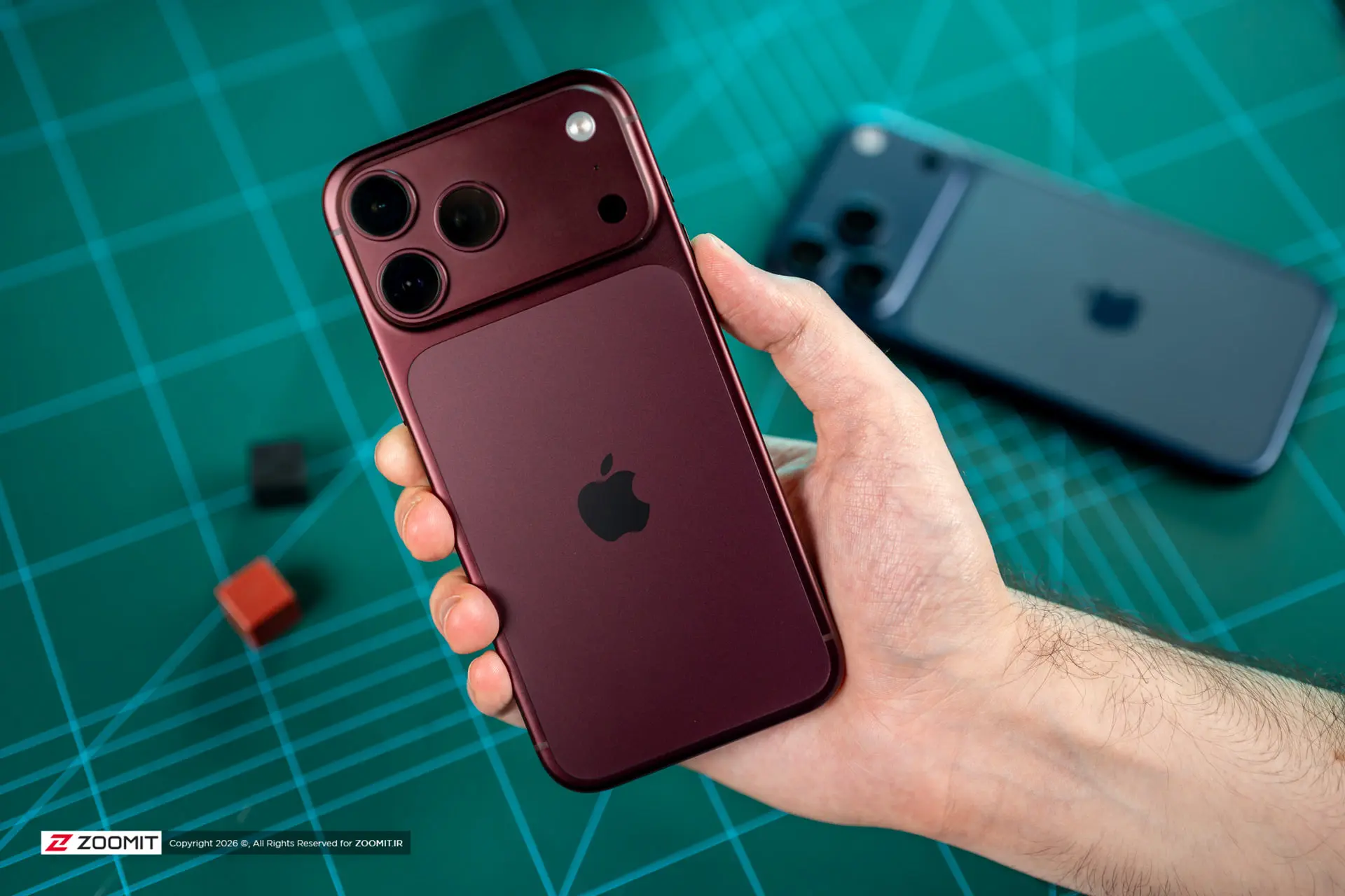 گوشی آیفون ۱۸ پرو مکس (iPhone 18 Pro Max) با رنگ زرشکی در دست